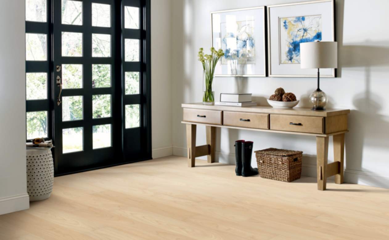 light luxury vinyl flooring in entryway with wood entry table and black door