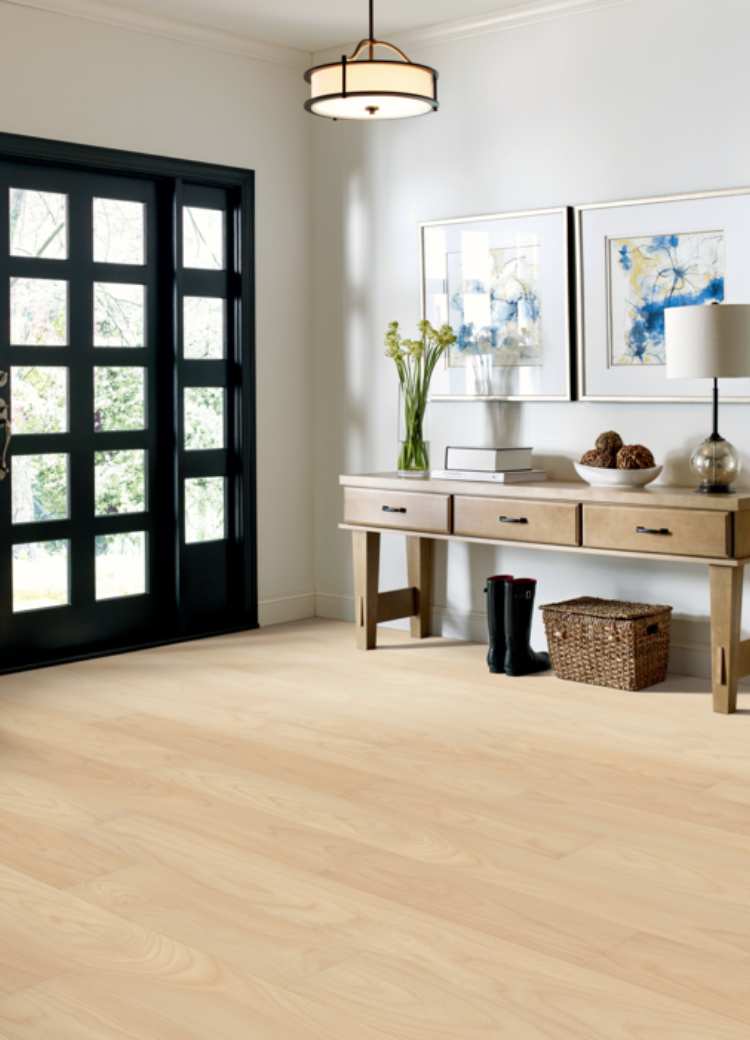 light luxury vinyl flooring in entryway with wood entry table and black door